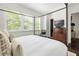 Bright bedroom features large windows, and antique dresser, bathed in natural light at 9121 Selborne Ln, Chattahoochee Hills, GA 30268