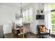 Dining room features a wooden table with seating for six, a tv and large windows at 9121 Selborne Ln, Chattahoochee Hills, GA 30268