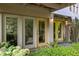 House exterior featuring a yellow door entrance, plants, and stone column at 9121 Selborne Ln, Chattahoochee Hills, GA 30268