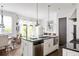 Modern kitchen features stainless steel appliances, white cabinets and black countertops and overlooks the dining area at 9121 Selborne Ln, Chattahoochee Hills, GA 30268