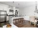 Open kitchen features stainless steel appliances, center island with dark countertops and bar stool seating at 9121 Selborne Ln, Chattahoochee Hills, GA 30268