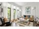 Bright living room featuring a comfortable couch and large windows overlooking the balcony at 9121 Selborne Ln, Chattahoochee Hills, GA 30268