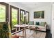 Bright living room with view of lush landscaping visible through large glass doors and windows at 9121 Selborne Ln, Chattahoochee Hills, GA 30268
