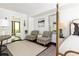 Relaxing bedroom space with patterned chairs and glimpses of living room through doorway at 9121 Selborne Ln, Chattahoochee Hills, GA 30268