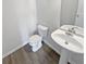 This bathroom features a pedestal sink, toilet, and wood-look vinyl flooring at 3180 Oakley Pl, Union City, GA 30291