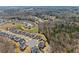 An aerial view showcases a residential development backing onto wooded areas and a pond at 4205 Rock Creek Dr, Cumming, GA 30028