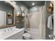 Well-lit bathroom with a shower-tub combo and decoratively appointed shelves at 4205 Rock Creek Dr, Cumming, GA 30028