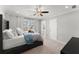 Well lit bedroom featuring a ceiling fan, neutral walls, carpet and an adjacent bathroom at 4205 Rock Creek Dr, Cumming, GA 30028