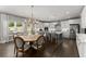 Bright dining area with an open view of the kitchen featuring white cabinets and stainless appliances at 4205 Rock Creek Dr, Cumming, GA 30028