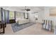 Bright main bedroom featuring a tray ceiling, ceiling fan, barn door access to the main bathroom and a sitting area at 4205 Rock Creek Dr, Cumming, GA 30028