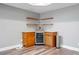 Finished basement featuring a mini bar with wood cabinets and shelving, a wine cooler, and an adjacent trash can at 4335 Halifax Ne Ter, Roswell, GA 30075