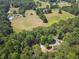 Aerial view of the property which shows open fields and trees with a home at 460 Rabbit Run, Mcdonough, GA 30252