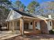 Spacious brick and siding carport featuring white trim, brick pillars, and a concrete pad at 460 Rabbit Run, Mcdonough, GA 30252