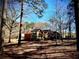 Exterior view of home through the tall pine trees and fallen pine needles at 460 Rabbit Run, Mcdonough, GA 30252