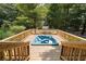 Wooden deck with built-in hot tub overlooking a scenic wooded lot at 460 Rabbit Run, Mcdonough, GA 30252