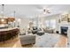 Open-concept living room with fireplace, ceiling fan, and seamless access to the kitchen at 302 Canter Way, Woodstock, GA 30188