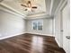 Main bedroom with tray ceiling, ceiling fan, hardwood floors, and large windows at 255 Pine Valley Dr, Powder Springs, GA 30127