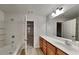 Bathroom featuring a tub with white tile surround and vanity with plenty of counter space at 5107 Madeline Pl, Stone Mountain, GA 30083