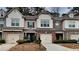 Charming townhome with brick and siding exterior, attached garages, and manicured landscaping at 5107 Madeline Pl, Stone Mountain, GA 30083