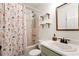 Cozy bathroom featuring a floral shower curtain, classic fixtures, and a mirrored vanity at 5532 Riverside Dr, Sugar Hill, GA 30518