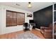 Office/bedroom space featuring a dark accent wall, hardwood floors, and ample light at 5532 Riverside Dr, Sugar Hill, GA 30518