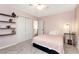 Charming bedroom featuring light pink walls, carpeted floors, and closet space at 5532 Riverside Dr, Sugar Hill, GA 30518