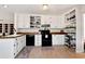 Well-lit kitchen with white cabinets, wood countertops, and black appliances at 5532 Riverside Dr, Sugar Hill, GA 30518