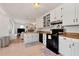 Cozy white kitchen with wooden countertops and modern black appliances at 5532 Riverside Dr, Sugar Hill, GA 30518