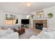 Bright living room featuring a stone fireplace, large windows, and hardwood floors at 5532 Riverside Dr, Sugar Hill, GA 30518