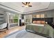 Inviting bedroom with a tray ceiling, a neutral palette, and plenty of natural light from large windows at 5532 Riverside Dr, Sugar Hill, GA 30518