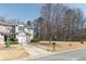 Attractive exterior view of a two-story home featuring a one-car garage, a neat lawn, and tree line at 573 Rendezvous Rd, Acworth, GA 30102