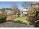 Private fenced backyard with stone patio, grass, and a charming garden gate at 10528 Serenbe Ln, Chattahoochee Hills, GA 30268
