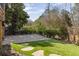 Paver patio and artificial grass backyard with mature trees and privacy fence at 10528 Serenbe Ln, Chattahoochee Hills, GA 30268