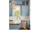 Bright kitchen showcasing blue cabinets, a farmhouse sink, stainless steel appliances, and modern lighting at 10528 Serenbe Ln, Chattahoochee Hills, GA 30268