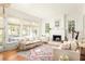 Comfortable living room featuring large windows, a decorative fireplace and stylish furnishings at 10528 Serenbe Ln, Chattahoochee Hills, GA 30268