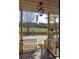 View of a covered porch overlooking the meadow with a fence at 10528 Serenbe Ln, Chattahoochee Hills, GA 30268