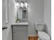 Elegant powder room with marble countertop, wood-look floors, modern fixtures, and neutral paint at 1284 Warsaw Rd, Roswell, GA 30076