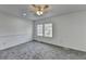 Neutral bedroom featuring plush carpet, a ceiling fan, and double hung windows at 1284 Warsaw Rd, Roswell, GA 30076