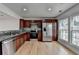 Well-lit kitchen with stainless steel appliances, granite countertops, and wooden cabinets offering ample storage at 1284 Warsaw Rd, Roswell, GA 30076