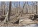 Peaceful backyard with mature trees, a bridge over creek, and natural surroundings at 5222 N Helton Rd, Winston, GA 30187