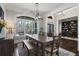 Dining room with a long wooden table and chairs, next to a glass window overlooking green foliage at 5222 N Helton Rd, Winston, GA 30187