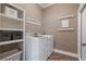 Convenient laundry room with white washer and dryer, storage shelves and cabinets, and sign at 5222 N Helton Rd, Winston, GA 30187