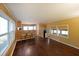 Open-concept living room and kitchen featuring wood paneling, a bar area, and modern appliances at 5400 Kings Camp Rd Se B-34, Acworth, GA 30102
