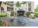 Inviting building entrance with a covered awning, lush landscaping, and multiple balconies at 1 Biscayne Nw Dr # 706, Atlanta, GA 30309
