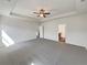 Large carpeted bedroom features a ceiling fan, tray ceiling, and entrance to a private bathroom at 3451 Meadow Grass Dr, Dacula, GA 30019