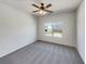 Carpeted bedroom filled with natural light from the window and complemented by a modern ceiling fan at 3451 Meadow Grass Dr, Dacula, GA 30019