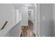 Upstairs hallway with wood floors, white trim, doors, and a view of the staircase at 3462 Mount Zion Rd, Stockbridge, GA 30281