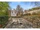 Backyard patio with stone pavers, retaining wall, and seating, surrounded by mature trees at 567 E Wesley Ne Rd, Atlanta, GA 30305