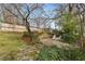 Landscaped backyard area with stone patio, retaining wall and a pair of white adirondack chairs at 567 E Wesley Ne Rd, Atlanta, GA 30305