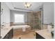 Bathroom featuring tray ceilings, marble tiling, a separate shower, and a tub at 567 E Wesley Ne Rd, Atlanta, GA 30305